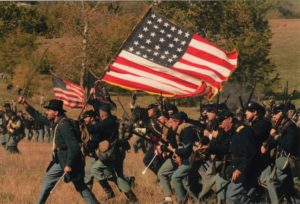 Actors in uniform holding the American Flag reenacting the history